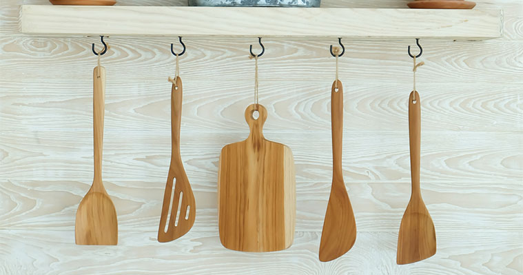 Organising kitchen by using cup hooks to hang utensils