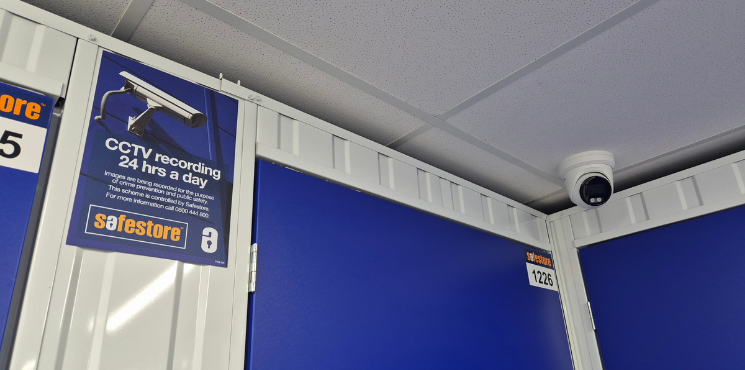 A CCTV camera inside Safestore Wembley alongside a poster that displays 24 hour CCTV