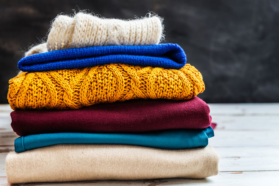 Organised winter wardrobe with folded jumpers