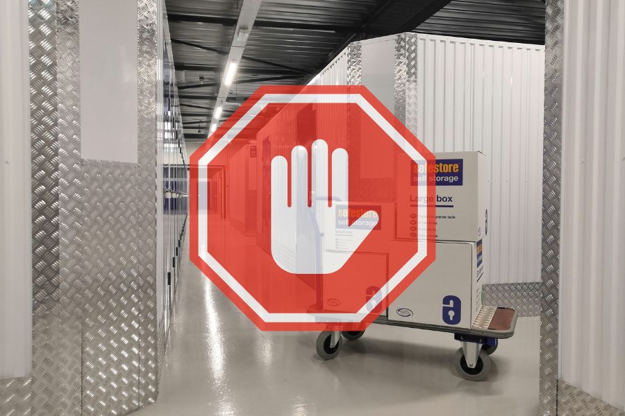 Storage unit hallway with trolley and boxes and a stop symbol indicating prohibited items.