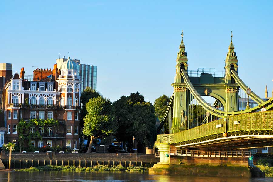 Hammersmith Bridge and riverside buildings in Fulham, SW6, London, captured on a sunny day. A scenic view highlighting the charm of living in SW6.